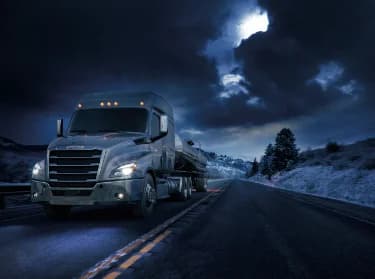 Truck on Canadian highway at night representing reliability and efficiency.